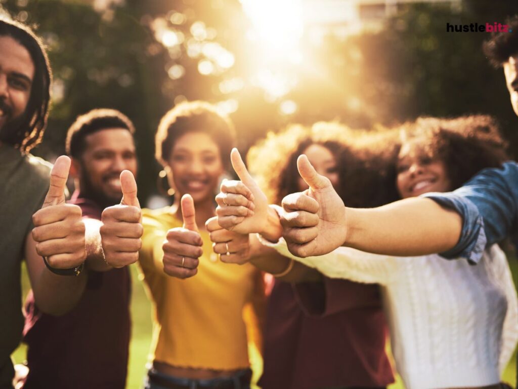 A group of people thumbs up to camera and smiles