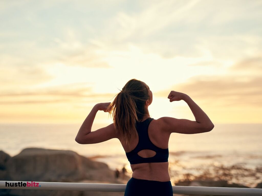 A woman raise her two hands facing the sea background