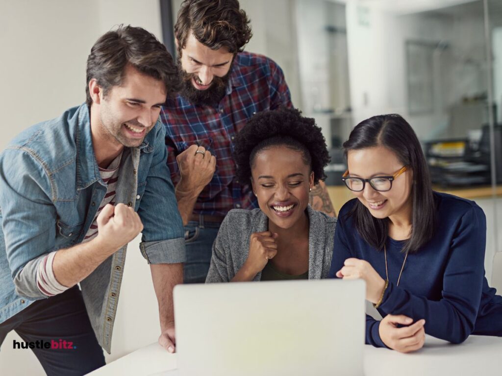 group of people looking at the laptop and smiling