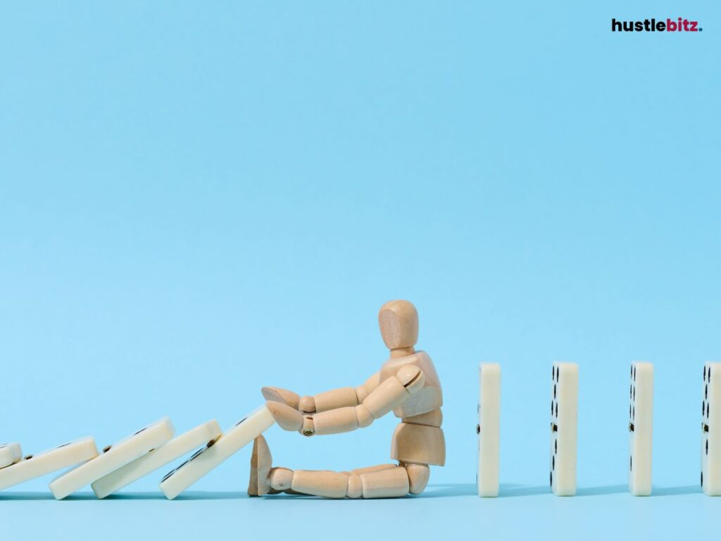 A wooden figure stopping falling dominoes.