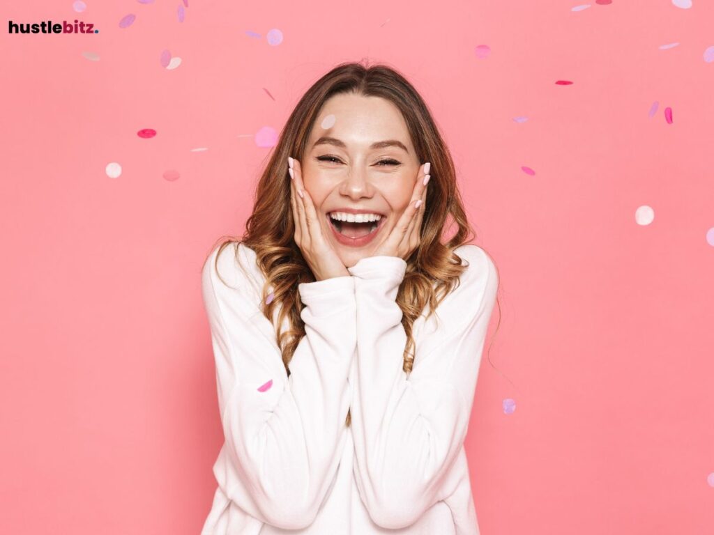 Excited woman smiling with confetti falling against a pink background.