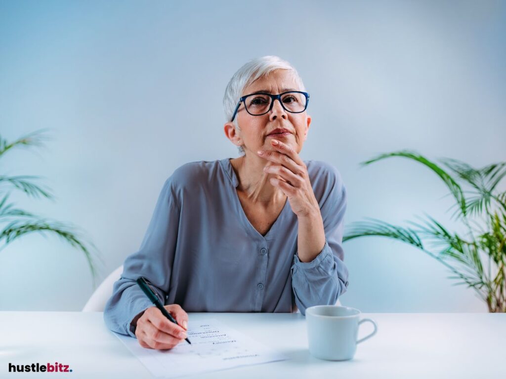 A woman deep in thought, writing notes at a table.