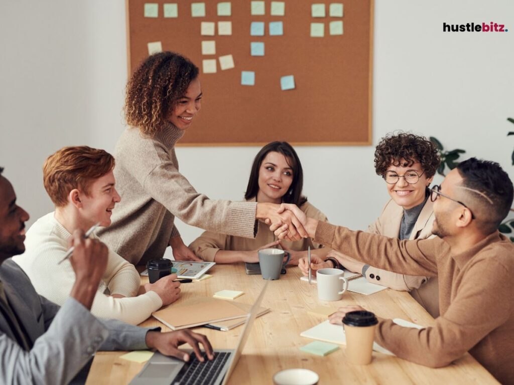 A group of people shake hands and smiles