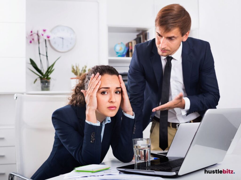 A man and woman inside the office and a laptop in the table