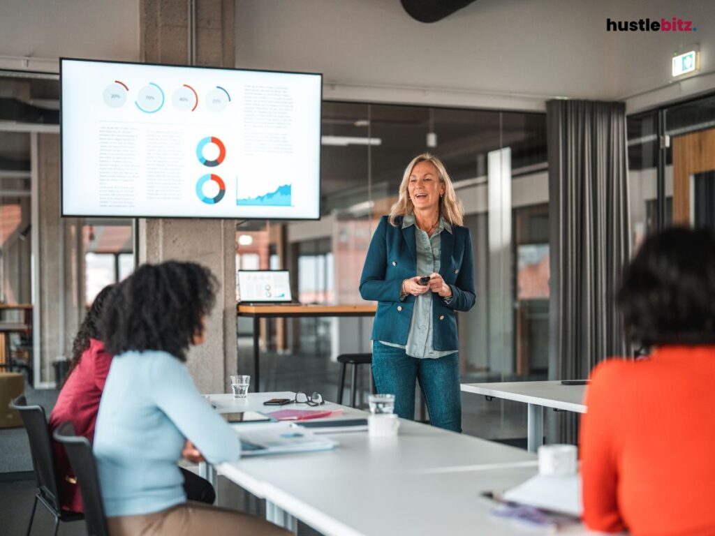 woman standing in front of people talking inside the office