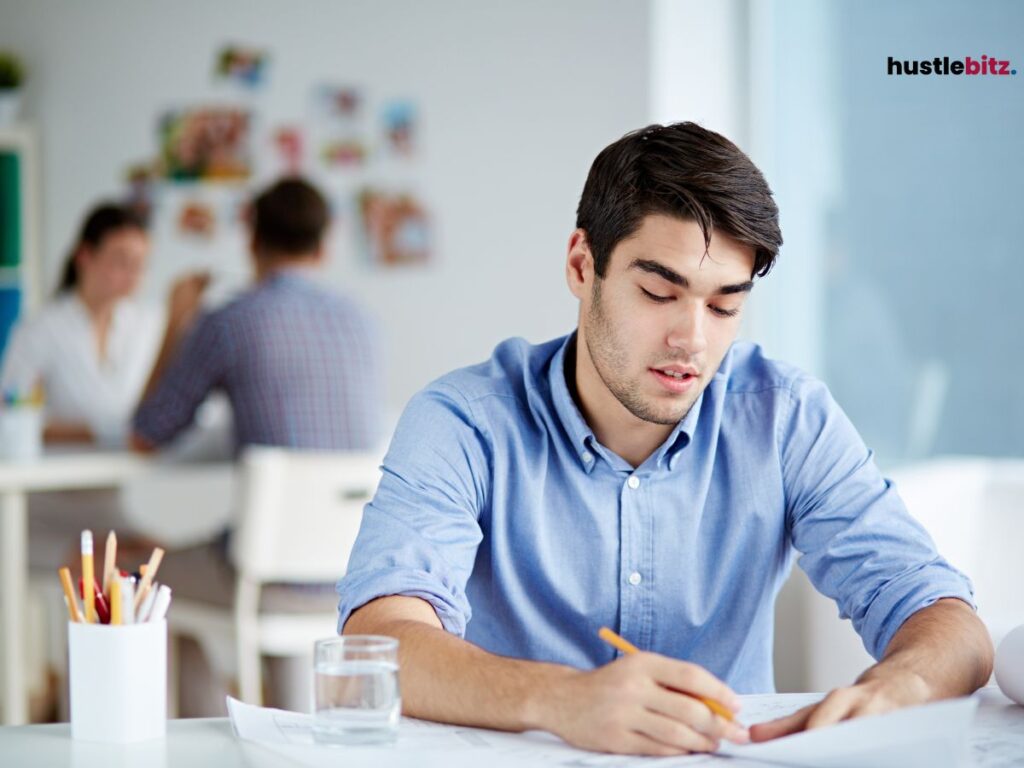 A  young man works alone at a desk, deeply focused on his tasks, symbolizing productivity.

