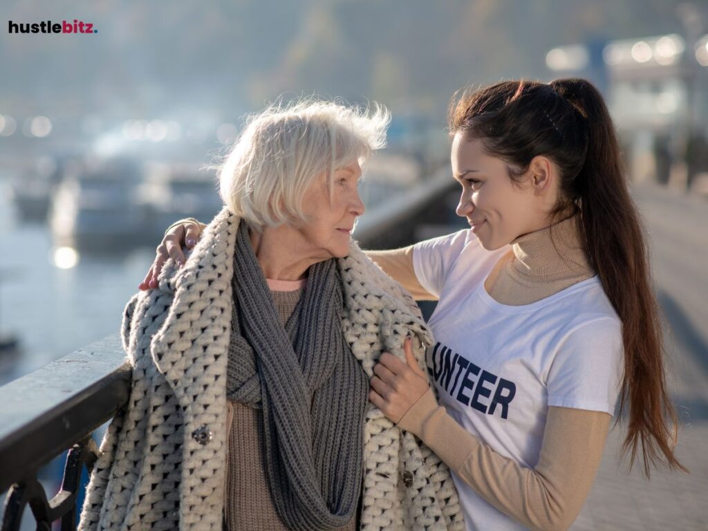  Young woman comforting an elderly lady outdoors.