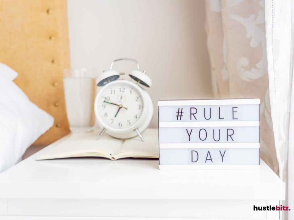 A bedside setup with an alarm clock and motivational message "#Rule Your Day."
