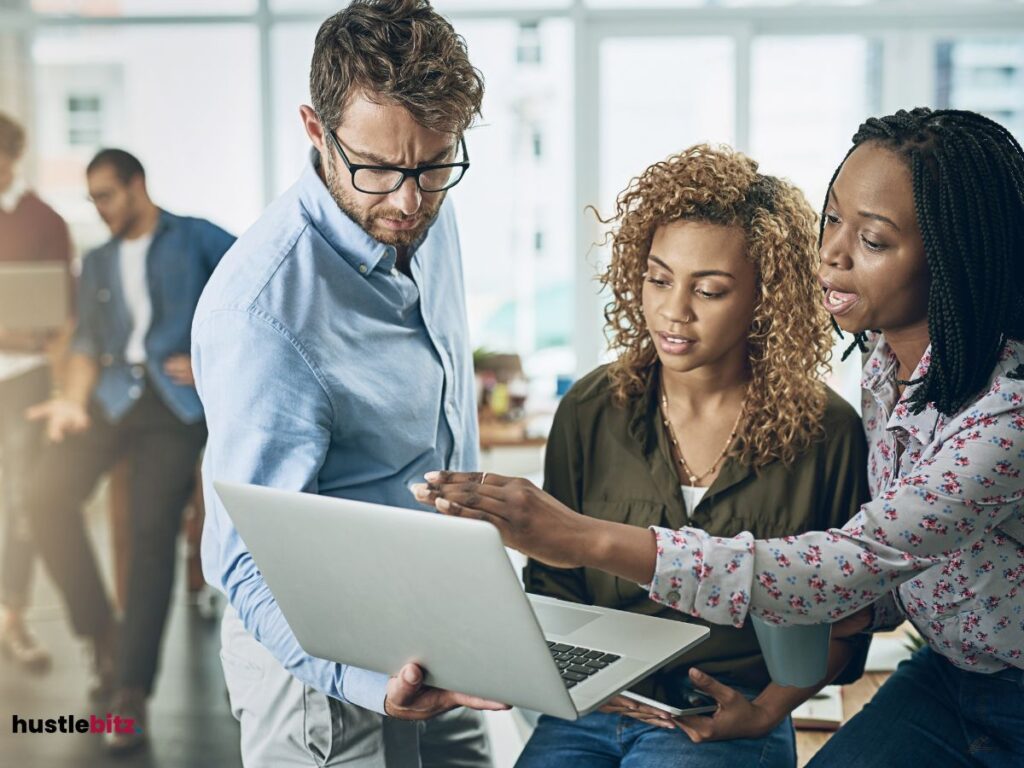 Three people looking at the laptop