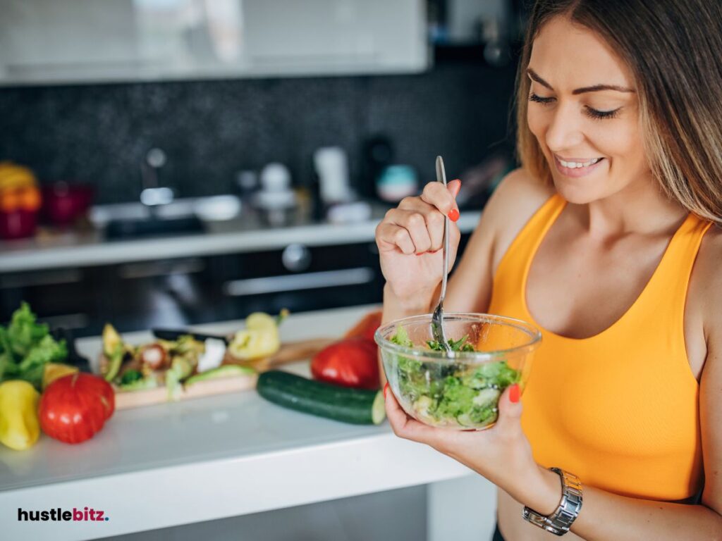 A woman eating healthy foods inside the kitchen