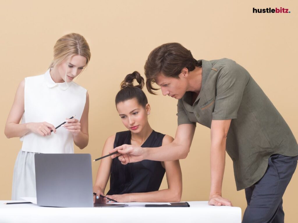 three people looking at the laptop