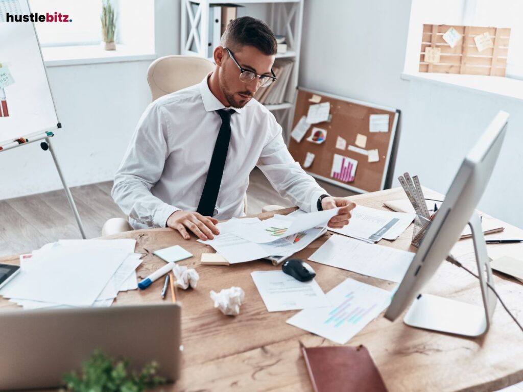 A businessman focused on documents, working hard at his desk.