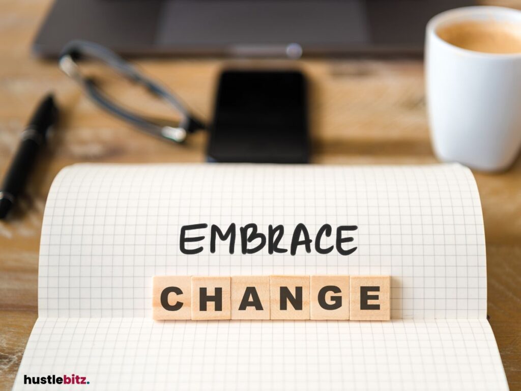 The words "Embrace Change" on a notebook, with office items in the background.