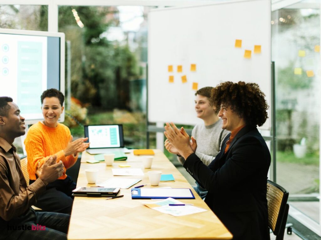 A group of people clapping to the man inside the office