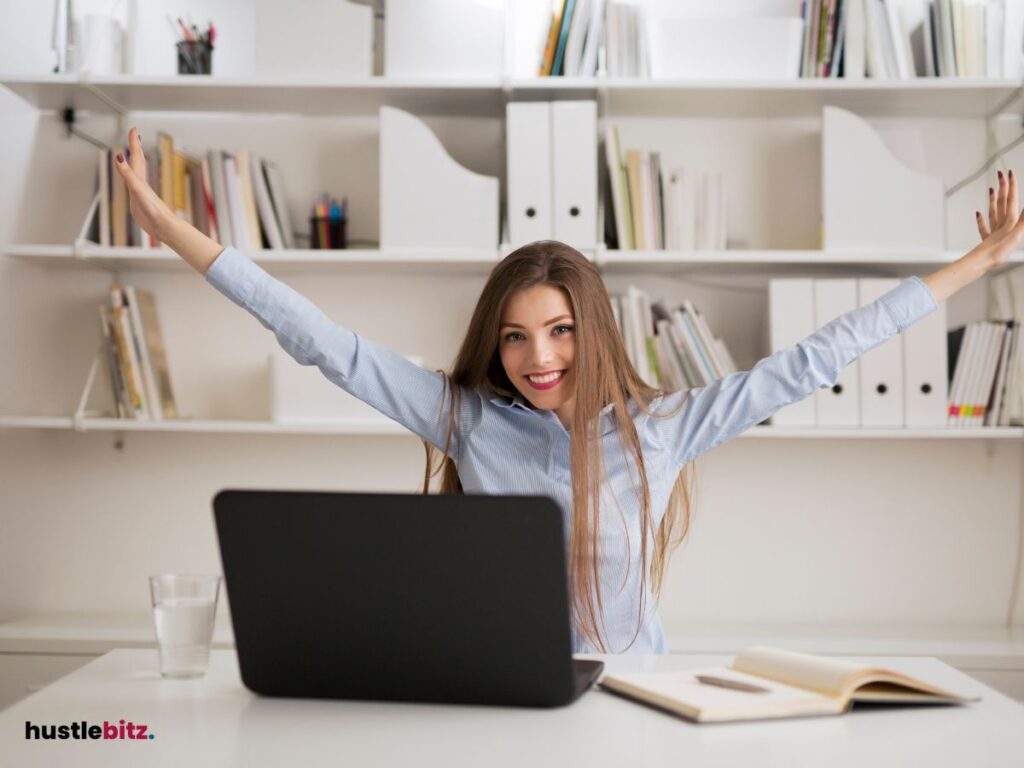 A woman raise her hands and a laptop in the table
