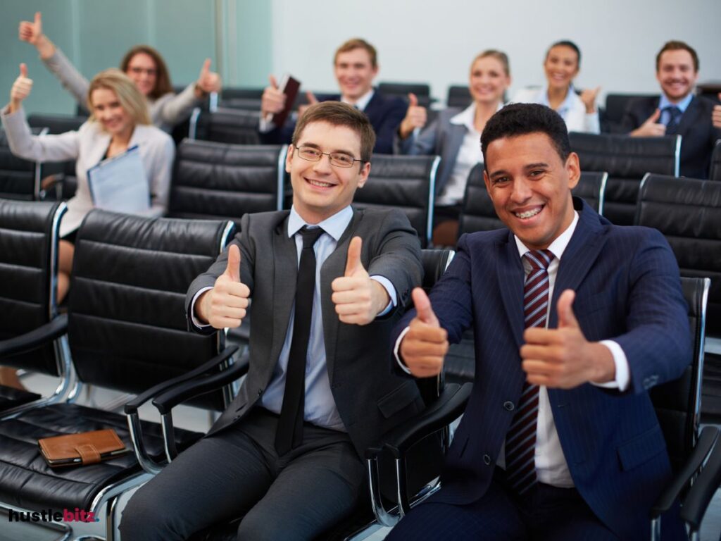 Group of professionals in suits giving thumbs-up in a conference room.