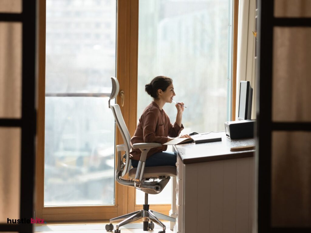 A woman inside the office doing work and facing the monitor