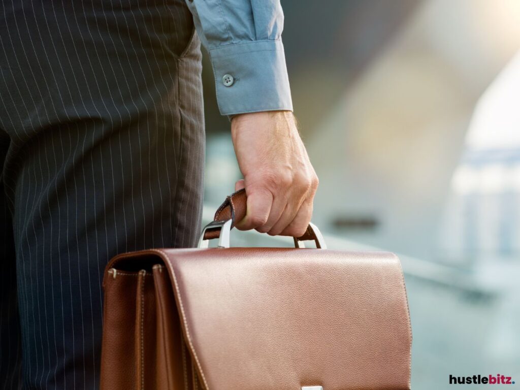 A picture of a person's hand carrying a brefcase.