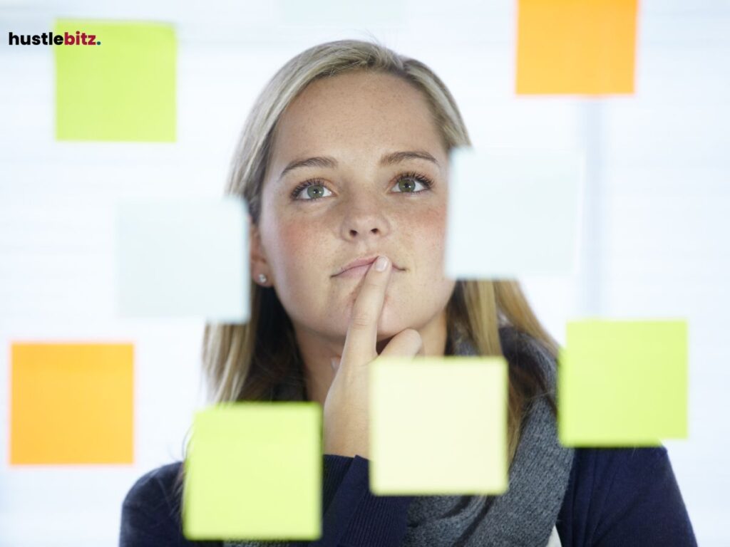  A woman thoughtfully looking at colorful sticky notes on a glass wall.