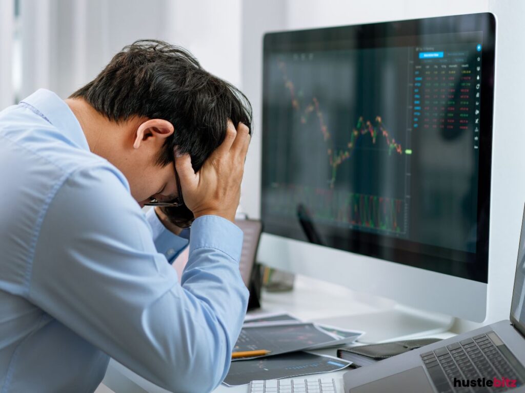 A man holding his head in front of the monitor