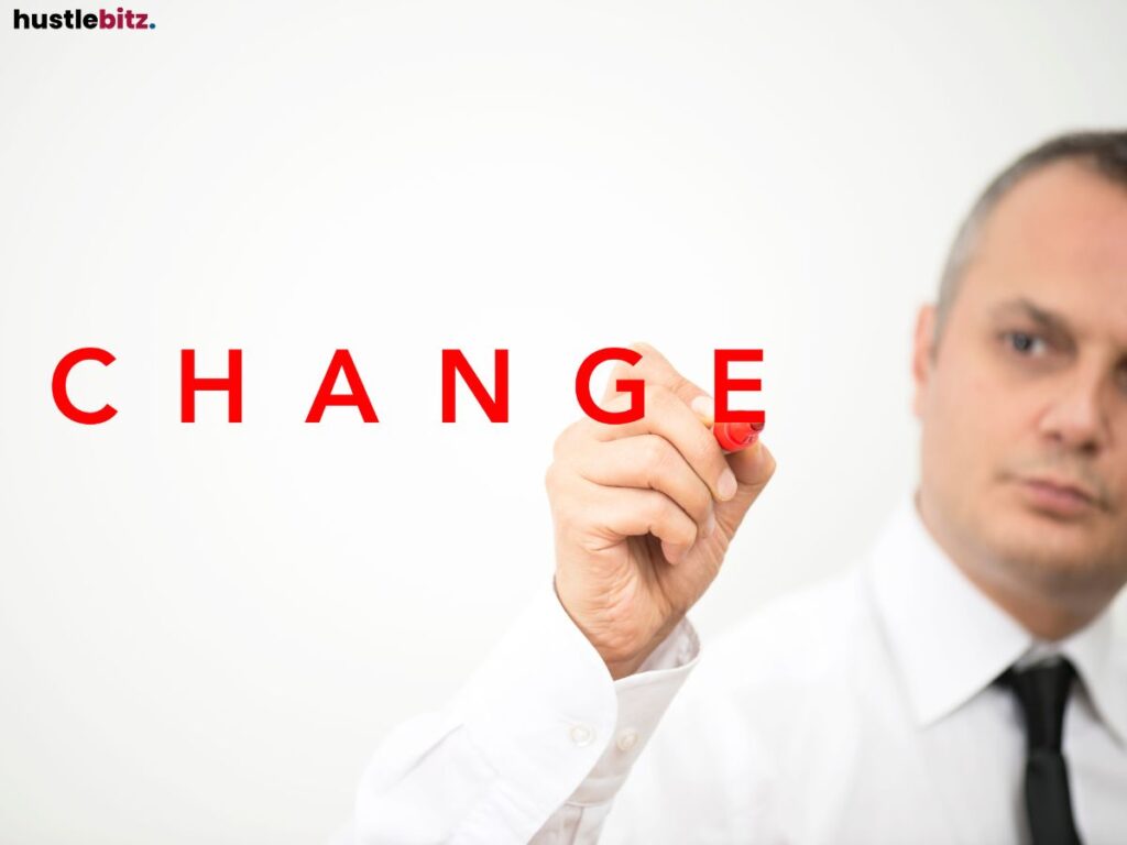 A person writing the word "CHANGE" in red letters.
