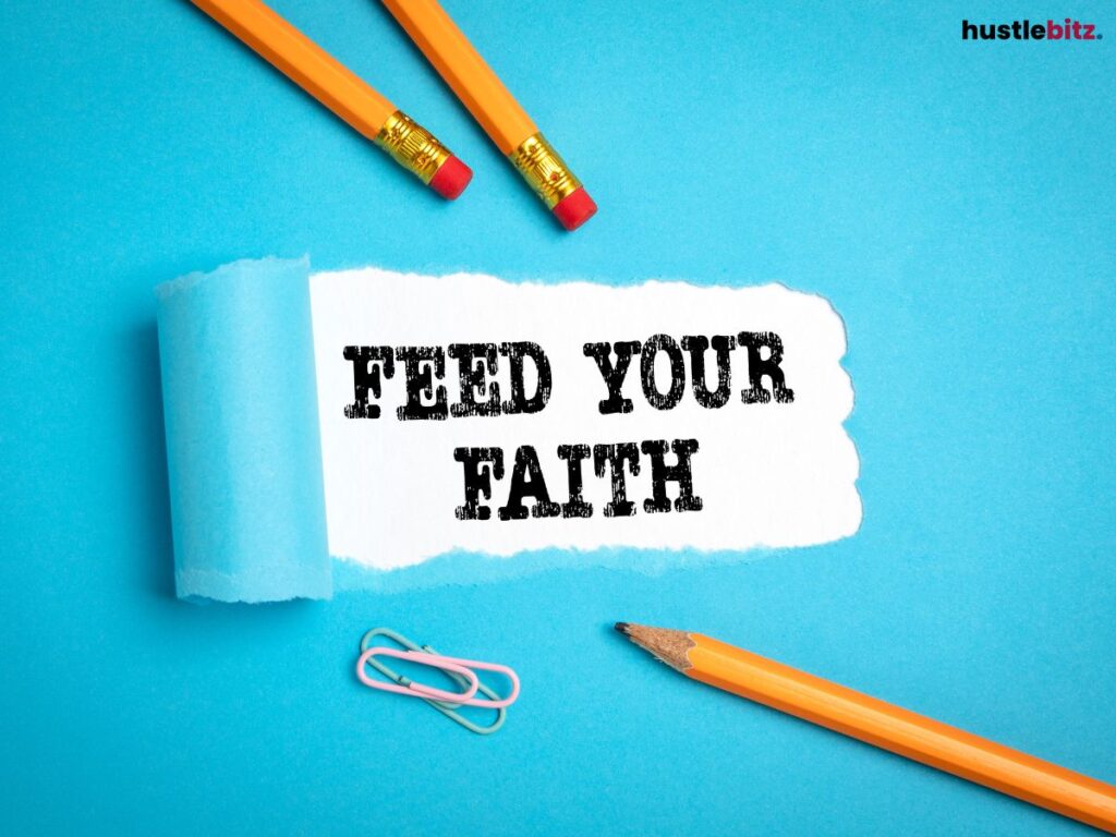 "Feed Your Faith" written on paper surrounded by pencils on a blue background.
