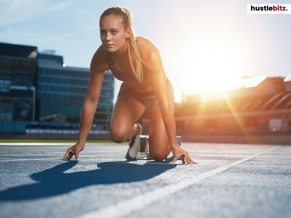 A determined athlete in starting position on a track, ready to sprint towards her goal.