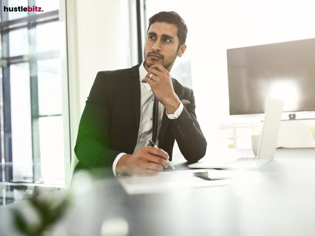 A thoughtful businessman sitting at his desk, planning with concentration.