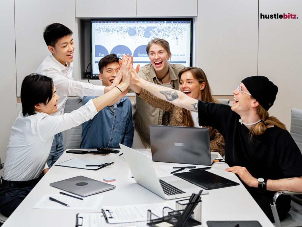 A group of people hold their hands inside the office