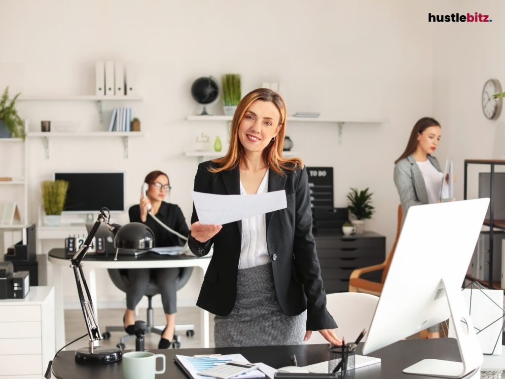 A confident businesswoman smiling while holding documents in a modern office environment.