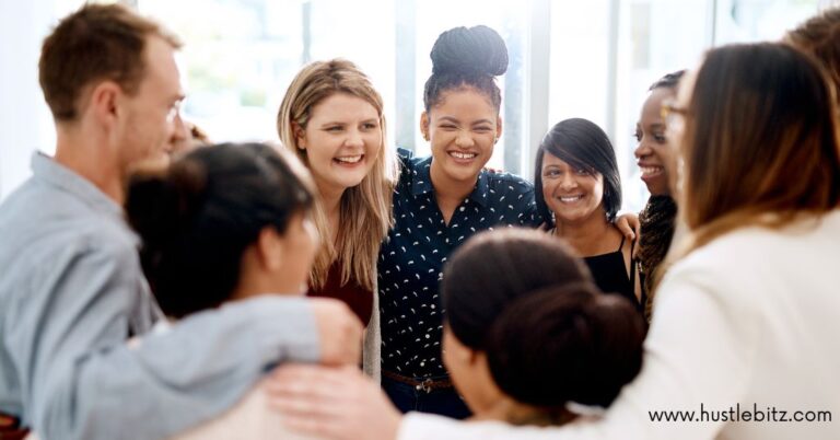 Group of diverse colleagues huddled together smiling.