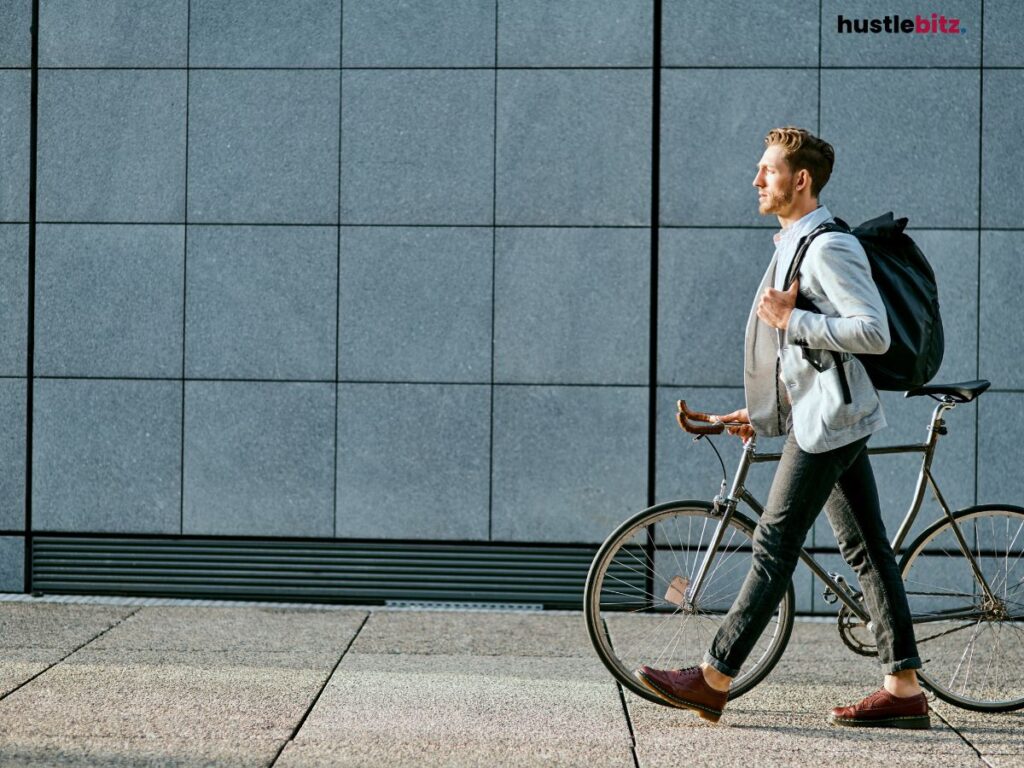 A man walks beside his bicycle, confidently heading towards work.