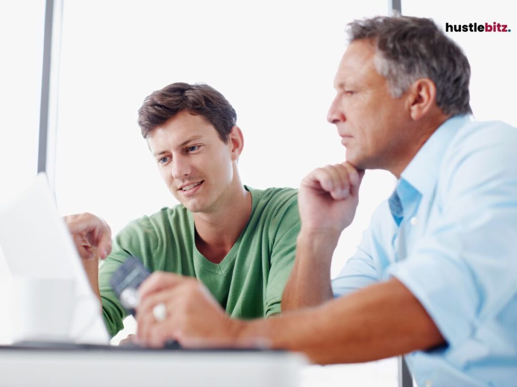 Two men talking and looking at the laptop