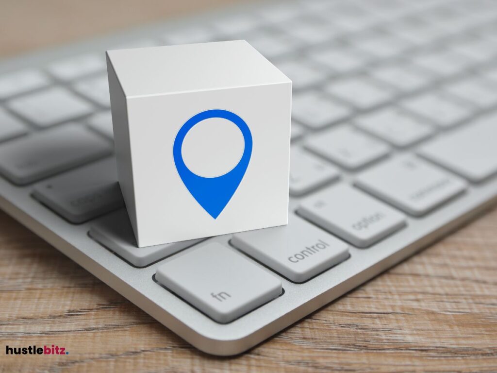 A cube with a location pin symbol resting on a keyboard.