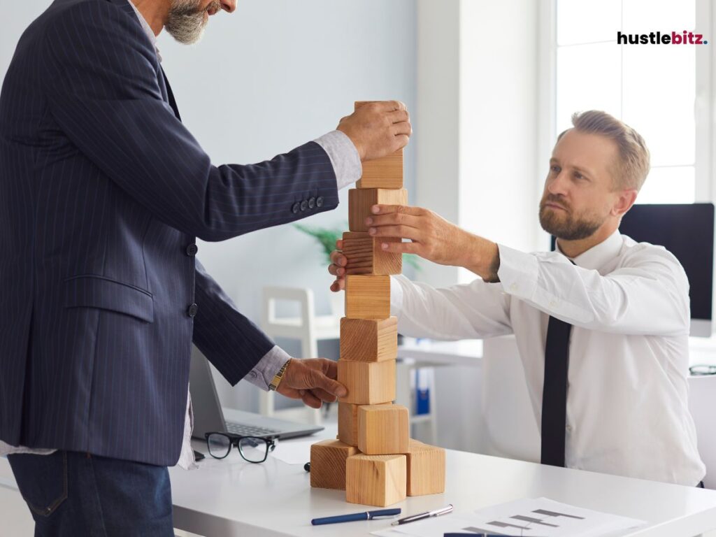 Two men in business attire stacking wooden blocks.