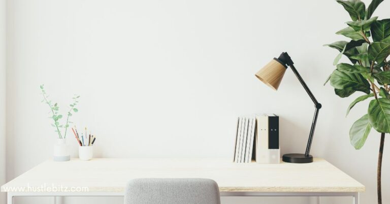 A minimalist desk setup with a lamp, books, and plants.