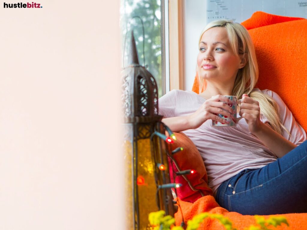 A blonde woman enjoying a cozy moment, sipping from a mug.