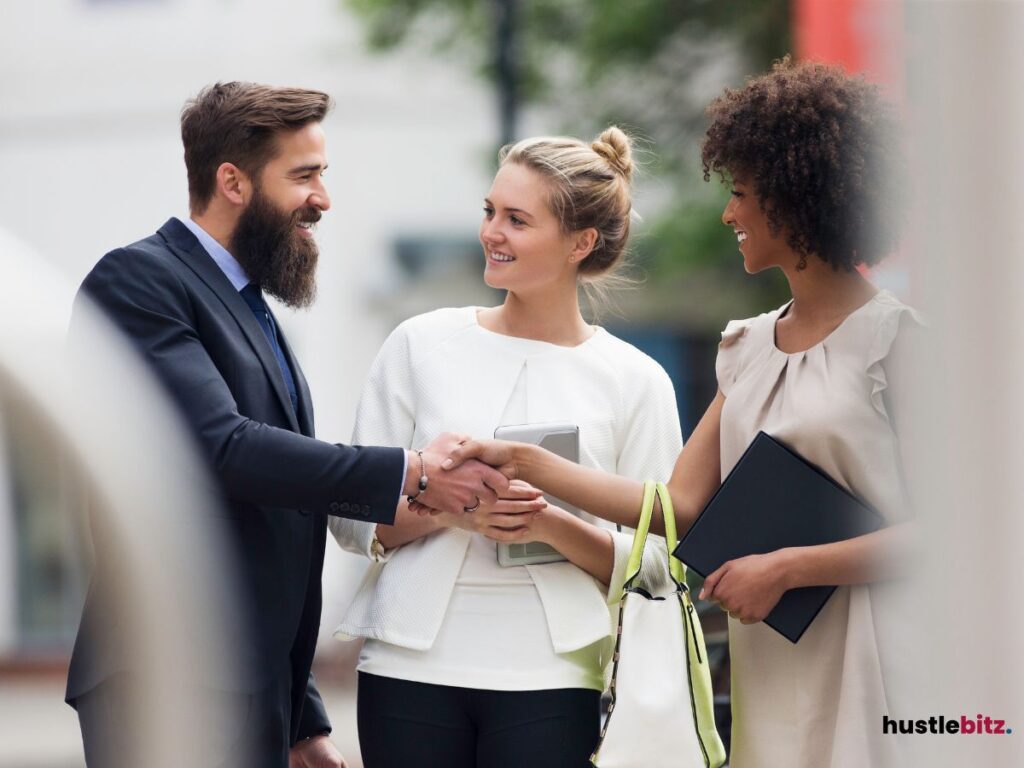 A man shake hands to the woman and smiles