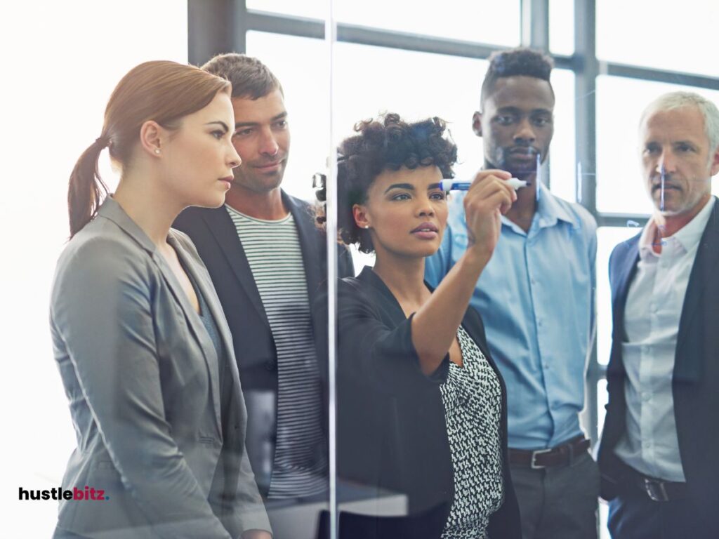 group of people standing and looking a the woman writing