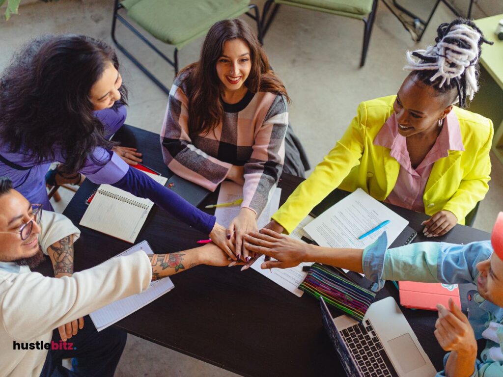 A group of people holding their hands together 