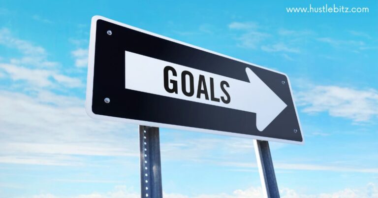 A black road sign with a word "GOAL" written in the white arrow.
