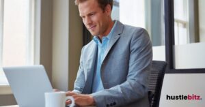 a man smiles and while looking at the laptop