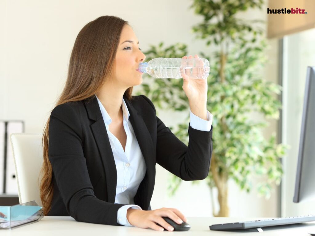 A woman drinking water inside the office