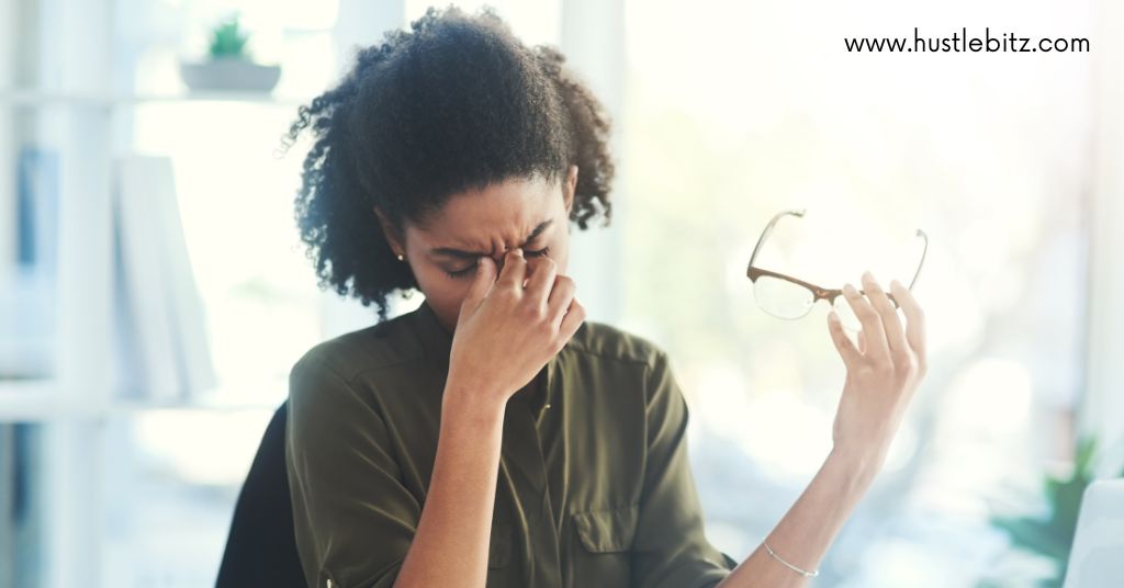 A woman in a moment of frustration or stress, sitting at a desk