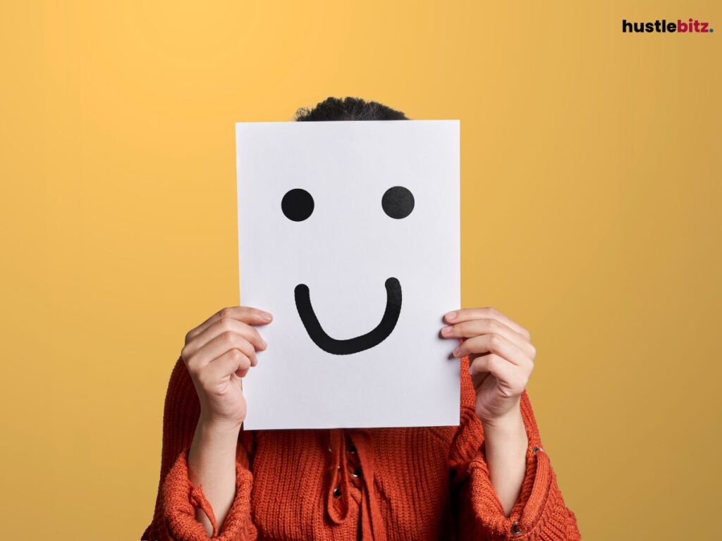 A person holding a paper with a smiley face covering her face.