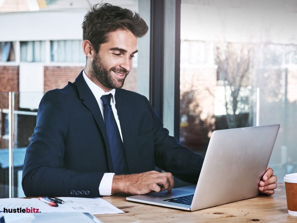 A man looking at the laptop and smiles