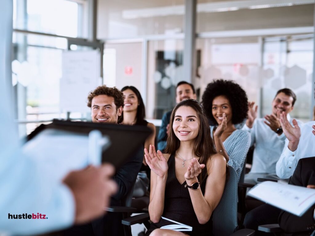 group of people clapping in front of the man