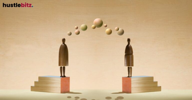 Two wooden figures on platforms exchange floating spheres.