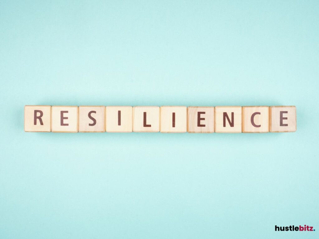 Wooden blocks spelling "RESILIENCE" on a pastel background.