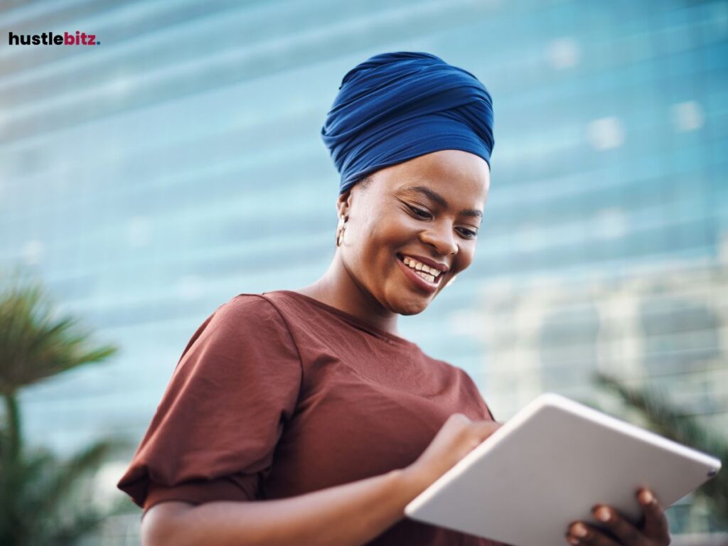 Woman smiling while using a tablet outdoors in a city.